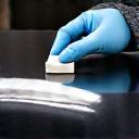 Applying a ceramic coating to a car's hood with an applicator block.