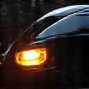 A detailer inspects a car's paint with a high-intensity swirl finder light.
